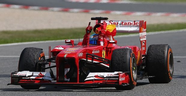 Fernando Alonso en su auto Ferrari levantando el dedo índice